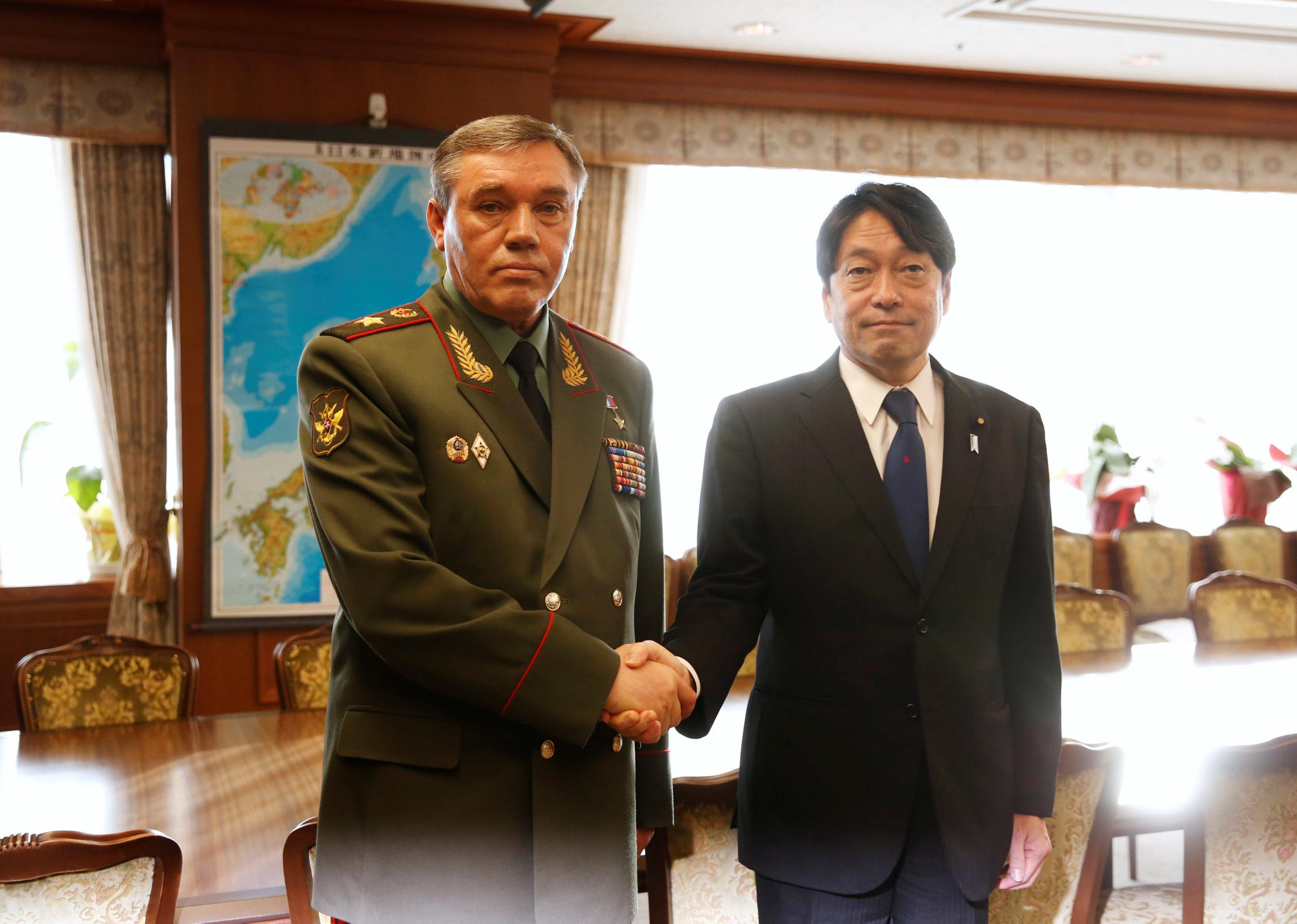 General Valery Gerasimov (left) shakes hands with Japan's Defense Minister Itsunori Onodera