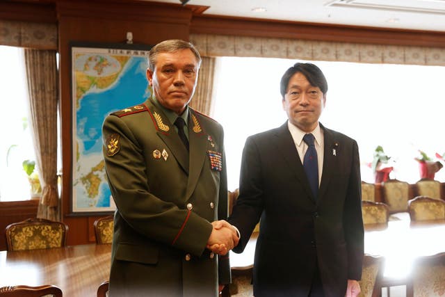 General Valery Gerasimov (left) shakes hands with Japan's Defense Minister Itsunori Onodera