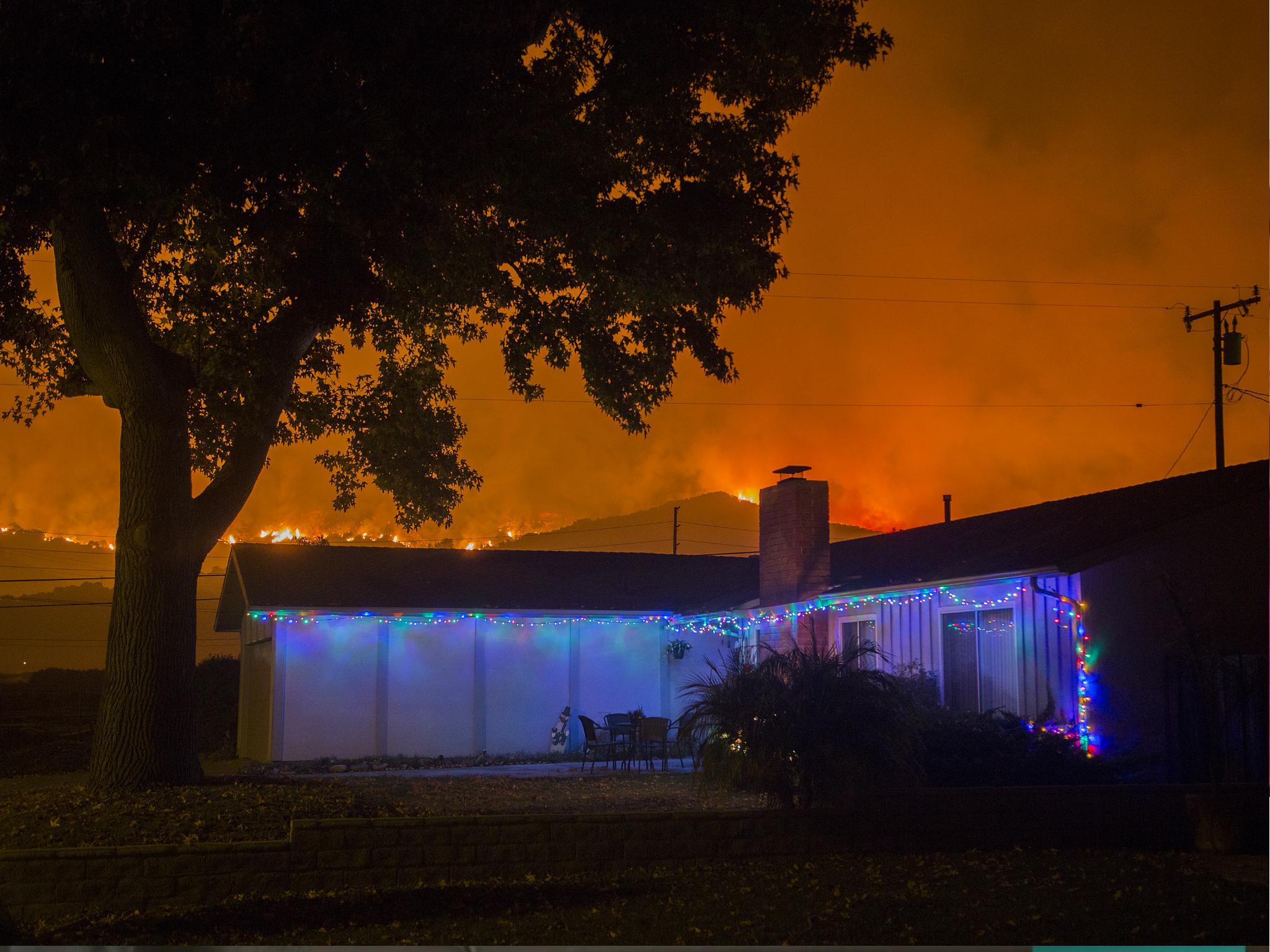 Christmas decorations illuminate a house as the growing Thomas Fire advances toward Santa Barbara County seaside communities on 10 December.