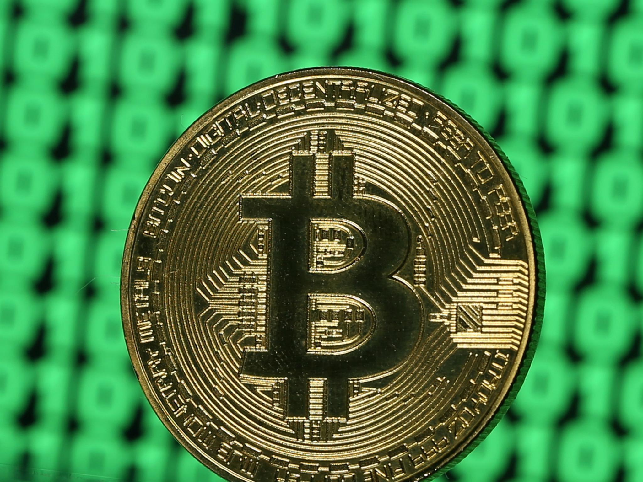 A token of the virtual currency Bitcoin is seen placed on a monitor that displays binary digits in this illustration picture, December 8, 2017