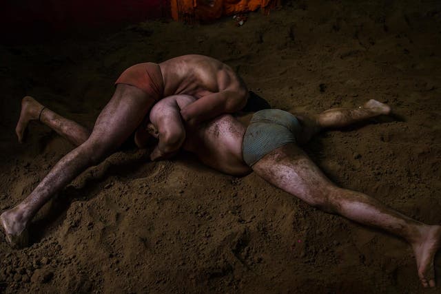 Indian kushti wrestlers fight in a ring in New Delhi, India