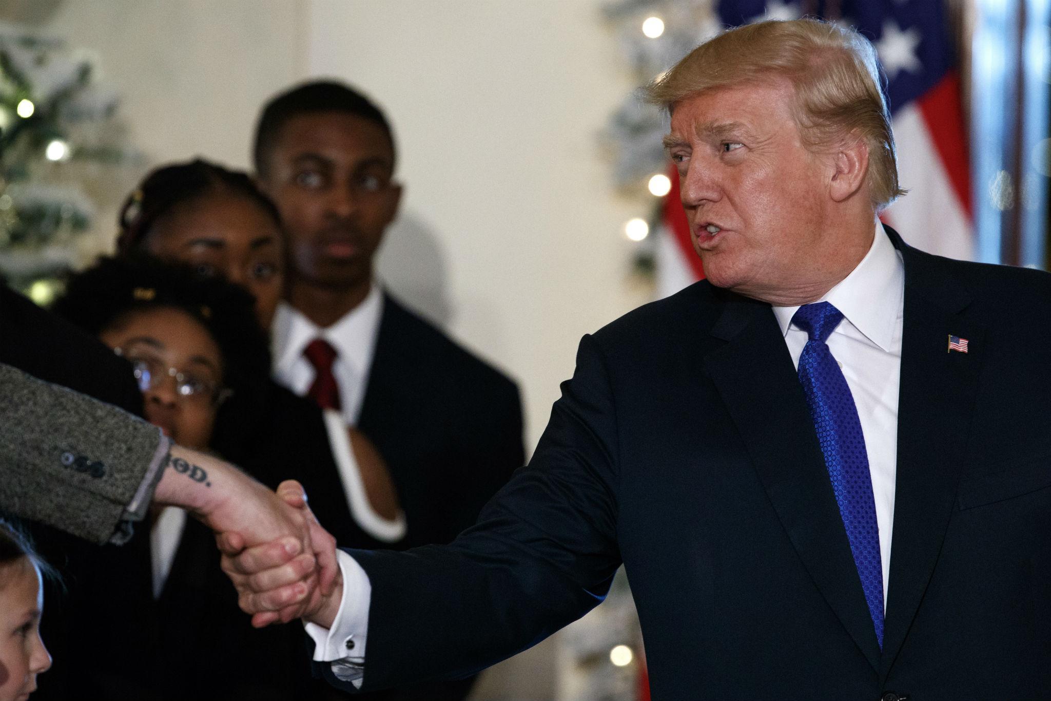 President Donald Trump shakes hands after speaking on tax reform in the Grand Foyer of the White House, Wednesday, Dec. 13, 2017, in Washington.