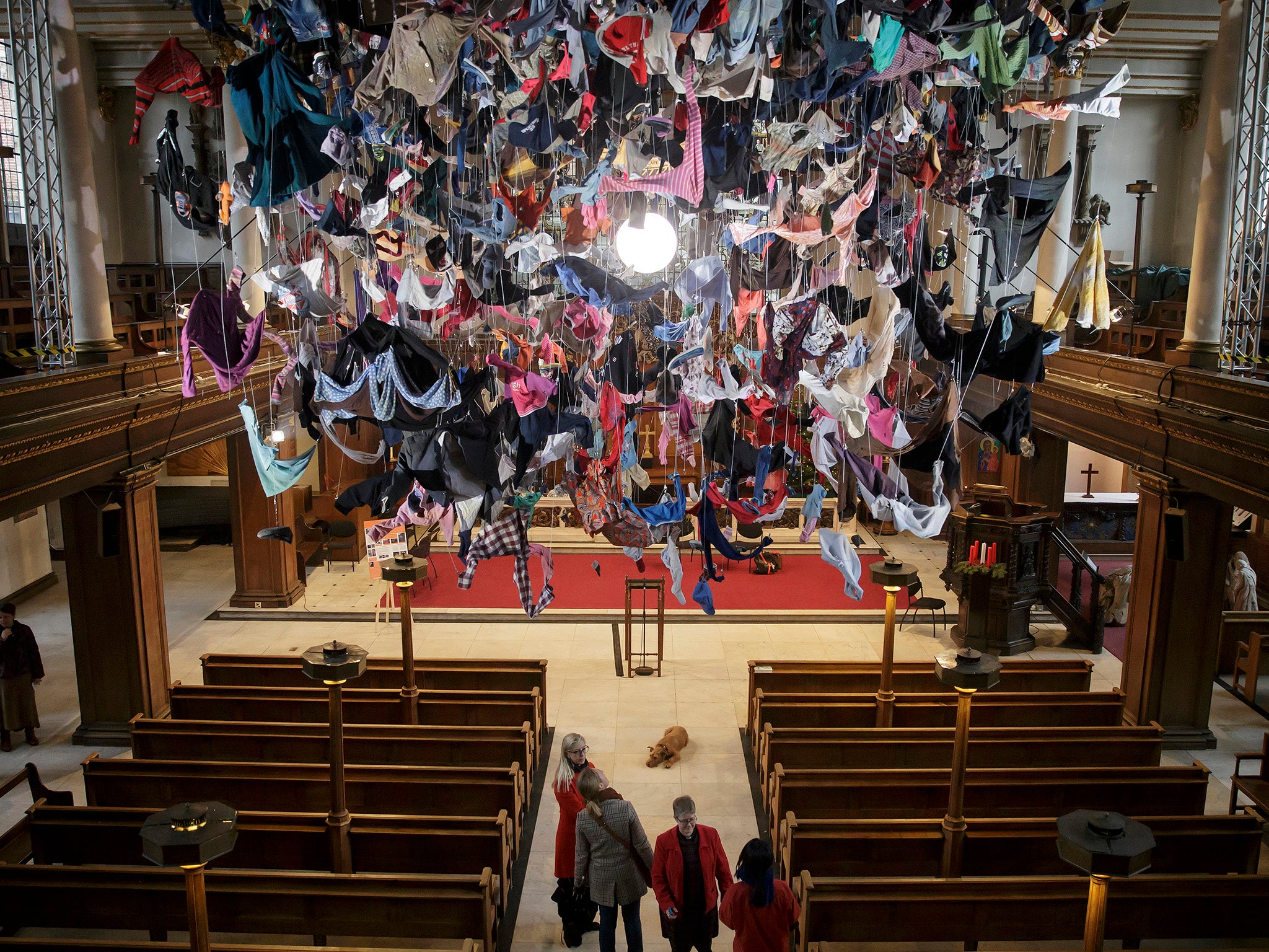 People view an installation artwork called Suspended, composed of items of clothing discarded by refugees on their arrival at Lesvos, by artist Arabella Dorman, at St James's Church on Piccadilly in London