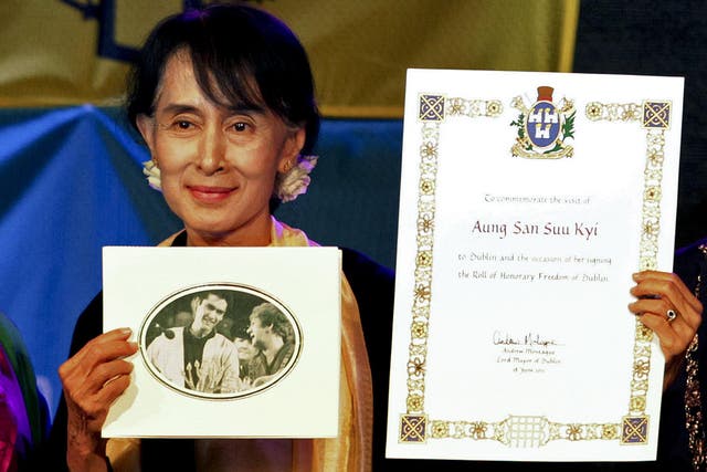 Aung San Suu Kyi holding up her freedom of the city during the ceremony in 2012 when she was finally able to collect the award