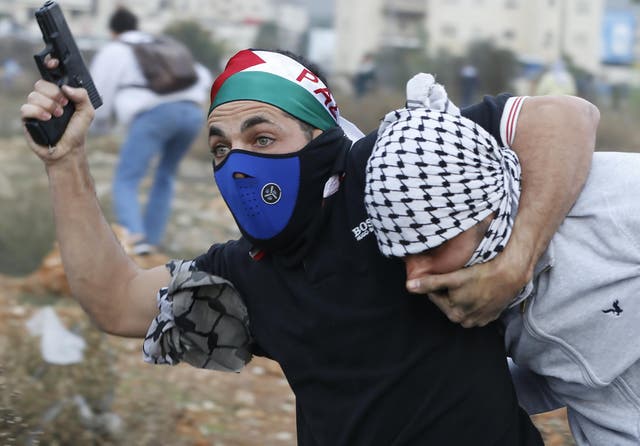 An undercover Israeli police officer detains a Palestinian protestor during clashes following a demonstration in the West Bank city of Ramallah on 13 December 2017