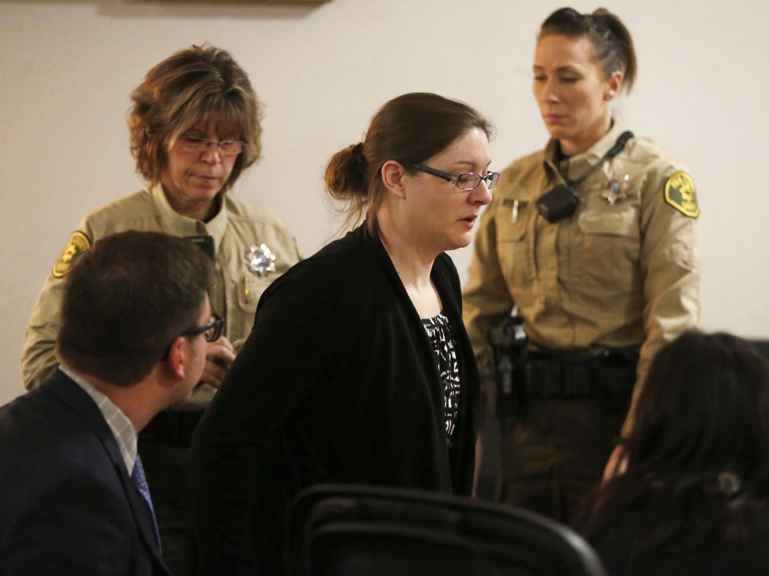 Nicole Finn stands as she is handcuffed by officers on Thursday 14 December 2017 after a jury found her guilty on kidnapping and murder charges in the starvation death of 16-year-old Natalie Finn at the Polk County Courthouse in Des Moines, Iowa