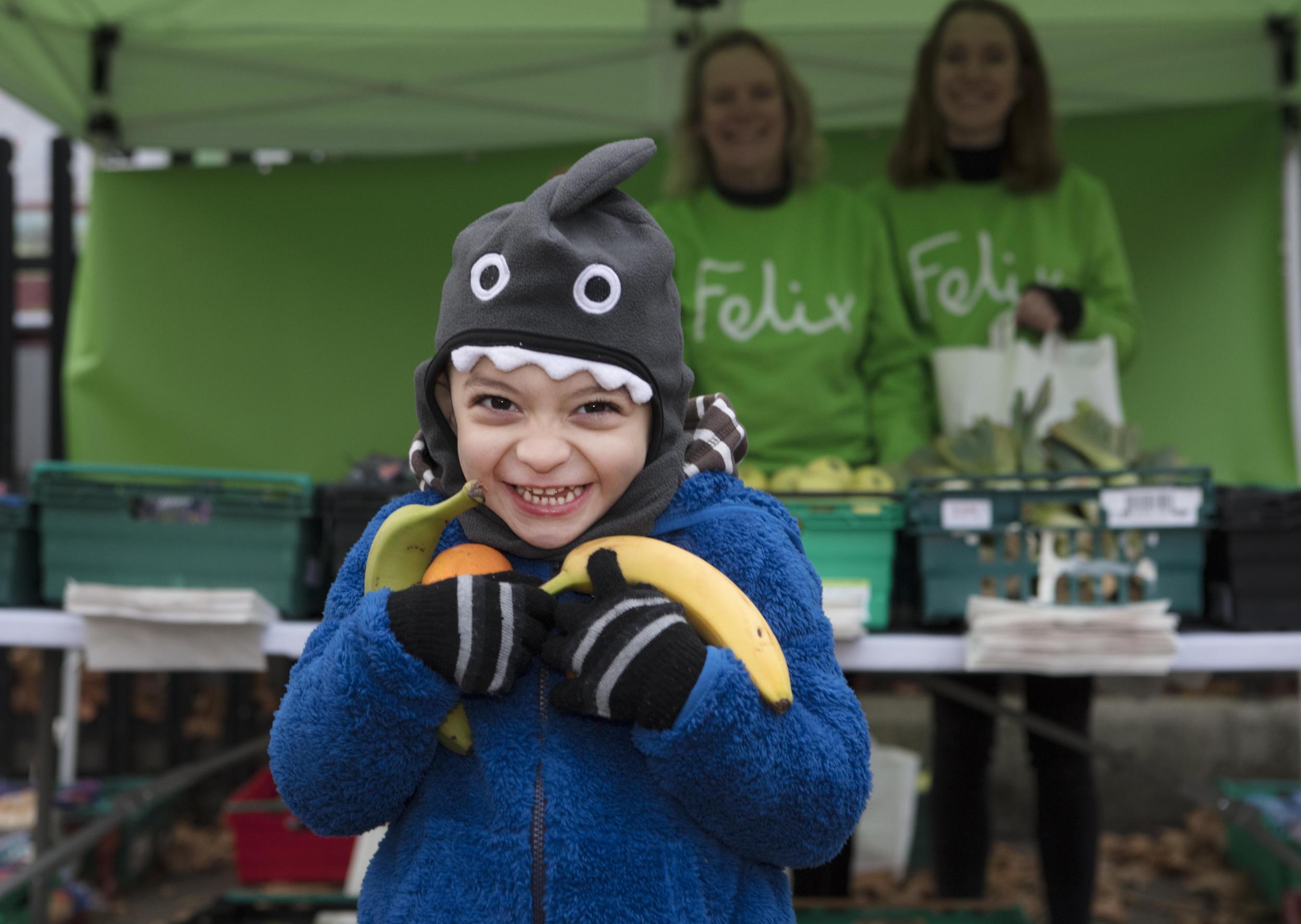 One of the first happy customers at the Felix Project's new market stall at Berrymede Junior School in west London