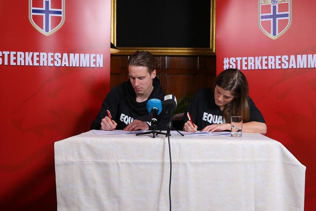 Stefan Johansen and Maren Mjelde, Norway's men's and women's captains, sign the agreement in London