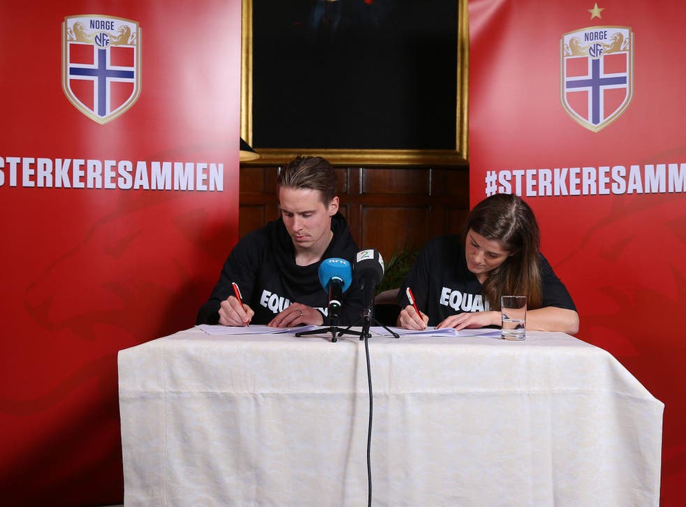 Stefan Johansen and Maren Mjelde, Norway's men's and women's captains, sign the agreement in London