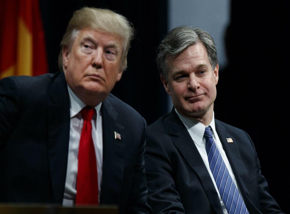Donald Trump sits with FBI Director Christopher Wray during the Bureau's National Academy graduation ceremony on Friday