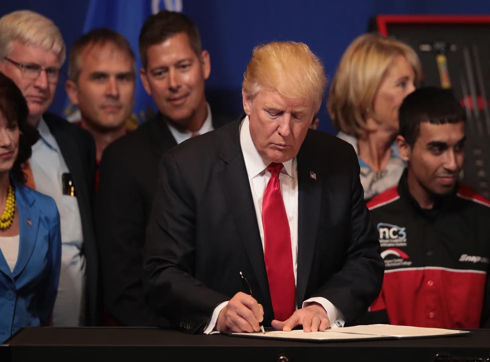 President Donald Trump signs an executive order to revamp the H-1B visa guest worker program