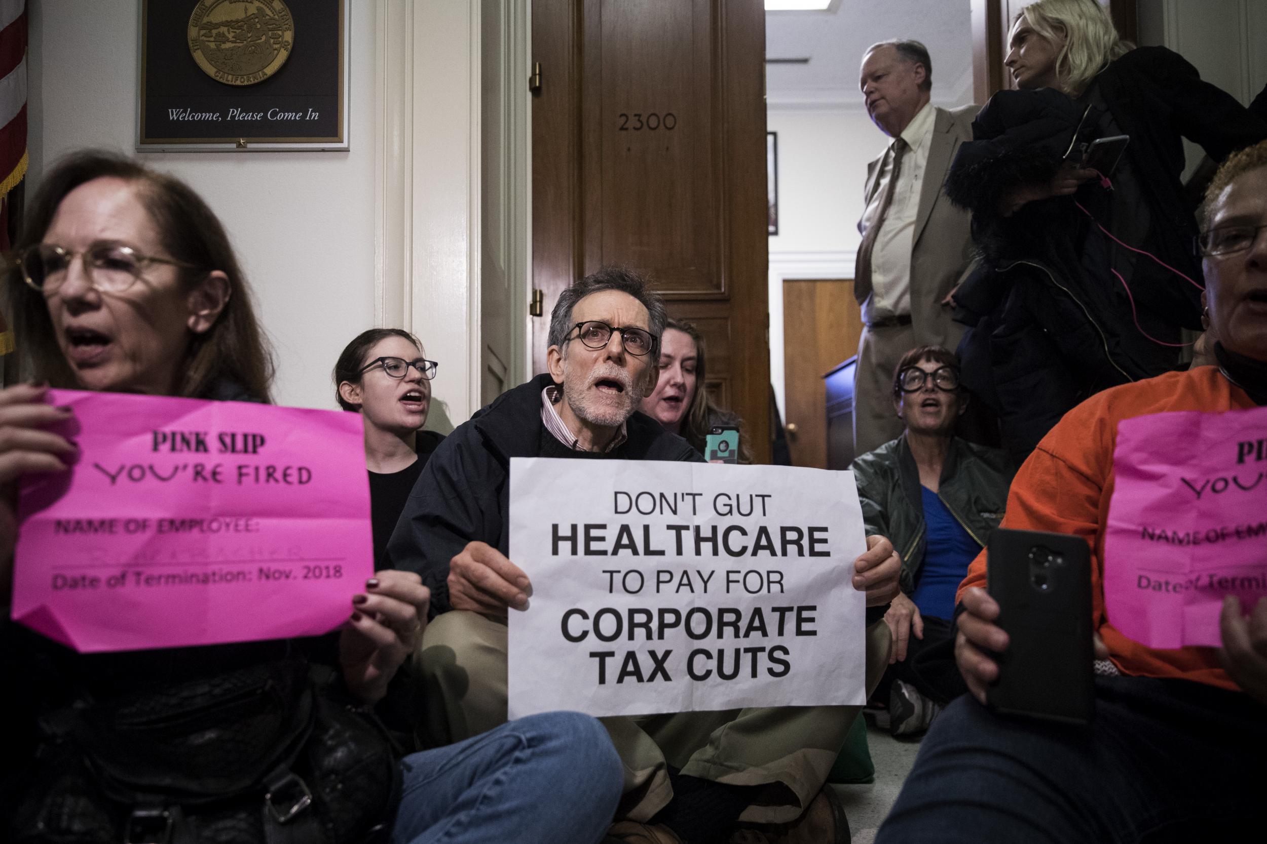 Activists stage a sit-in to protest the GOP tax reform bill outside of office of Representative Dana Rohrabacher