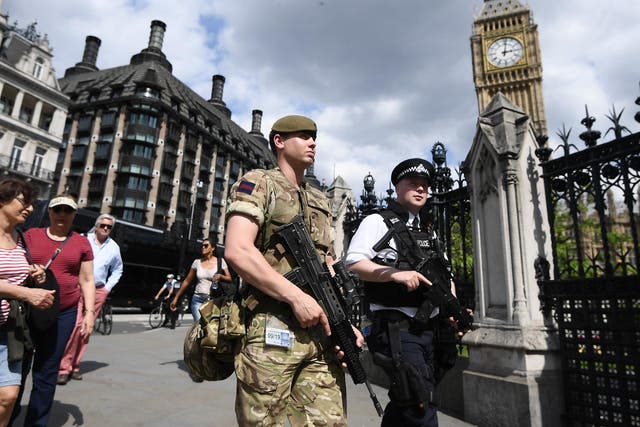 Armed soldier patrolling with armed police officer outside the Palace of Westminster in the days after the Manchester bombing when the terror threat level was raised to critical