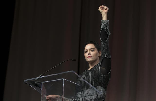 US actress Rose McGowan raises her fist during her opening remarks to the audience at the Women's March / Women's Convention in Detroit, Michigan, on October 27, 2017. Photo credit: RENA LAVERTY/AFP/Getty Images.