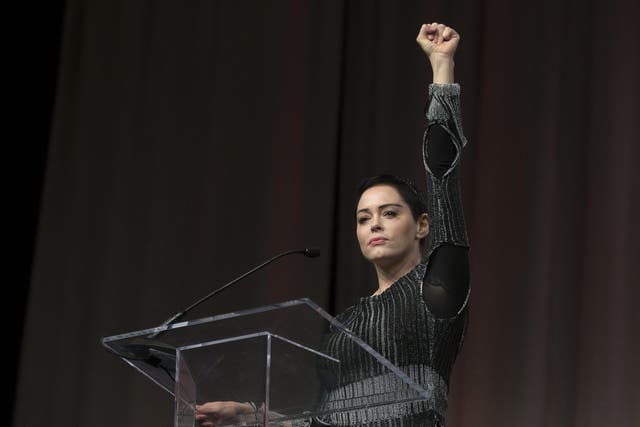 US actress Rose McGowan raises her fist during her opening remarks to the audience at the Women's March / Women's Convention in Detroit, Michigan, on October 27, 2017. Photo credit: RENA LAVERTY/AFP/Getty Images.