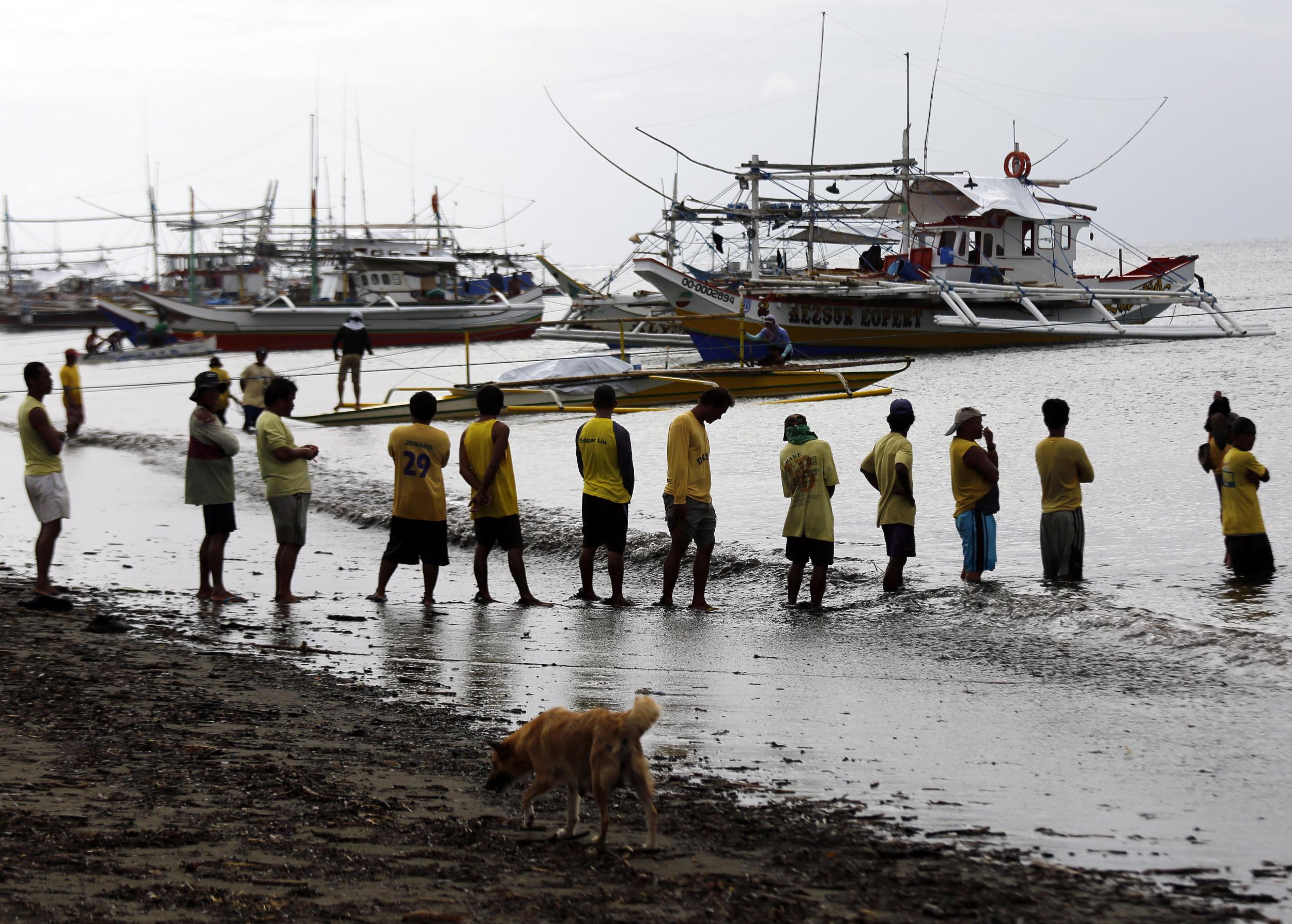 Filipino port workers wait for passenger vessel at a port in the coastal town of Infanta, Quezon province, in November 2016