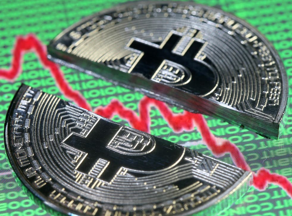 Broken representation of the Bitcoin virtual currency, placed on a monitor that displays stock graph and binary codes, are seen in this illustration picture, December 21, 2017