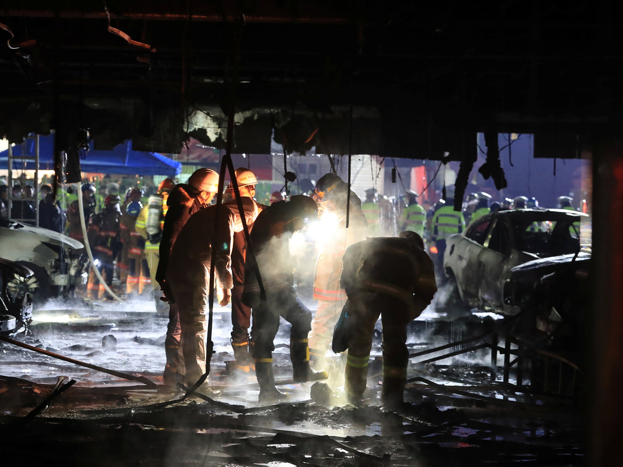 Firefighters examine the burned building