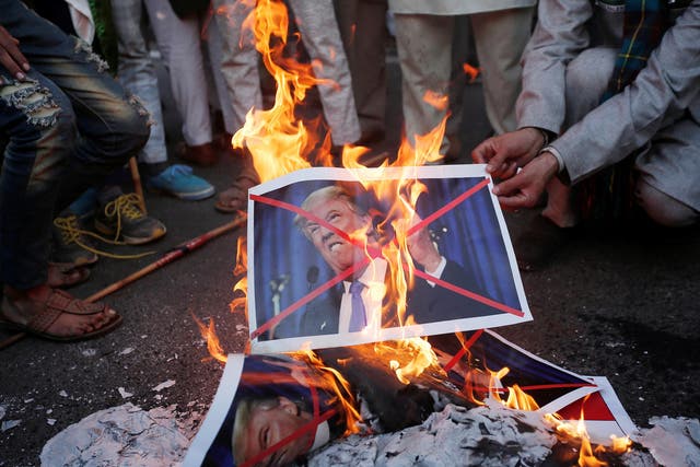 Protesters burn posters of US President Donald Trump during a protest against the US decision to recognise Jerusalem as the capital of Israel