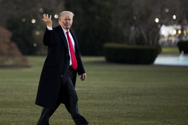 President Donald Trump gestures to reporters asking questions as he returns to the White House on 21 December