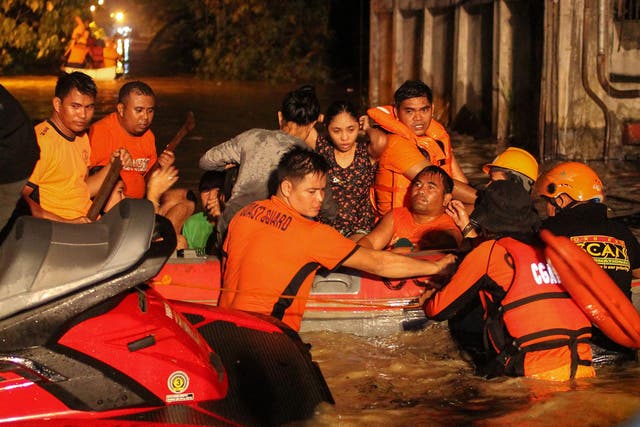 Rescue workers evacuate flood-affected residents in Davao on the southern Philippine island of Mindanao after Tropical Storm Tembin dumped torrential rains across the island