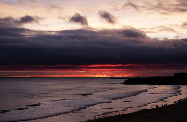 The sun rises on Christmas Day by the lighthouse at Tynemouth, Tyne and Wear.