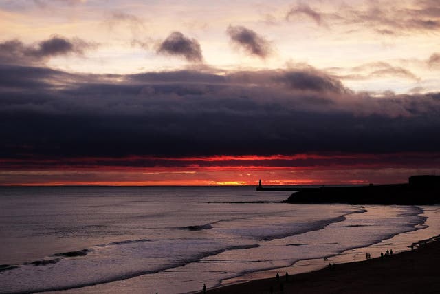 The sun rises on Christmas Day by the lighthouse at Tynemouth, Tyne and Wear.