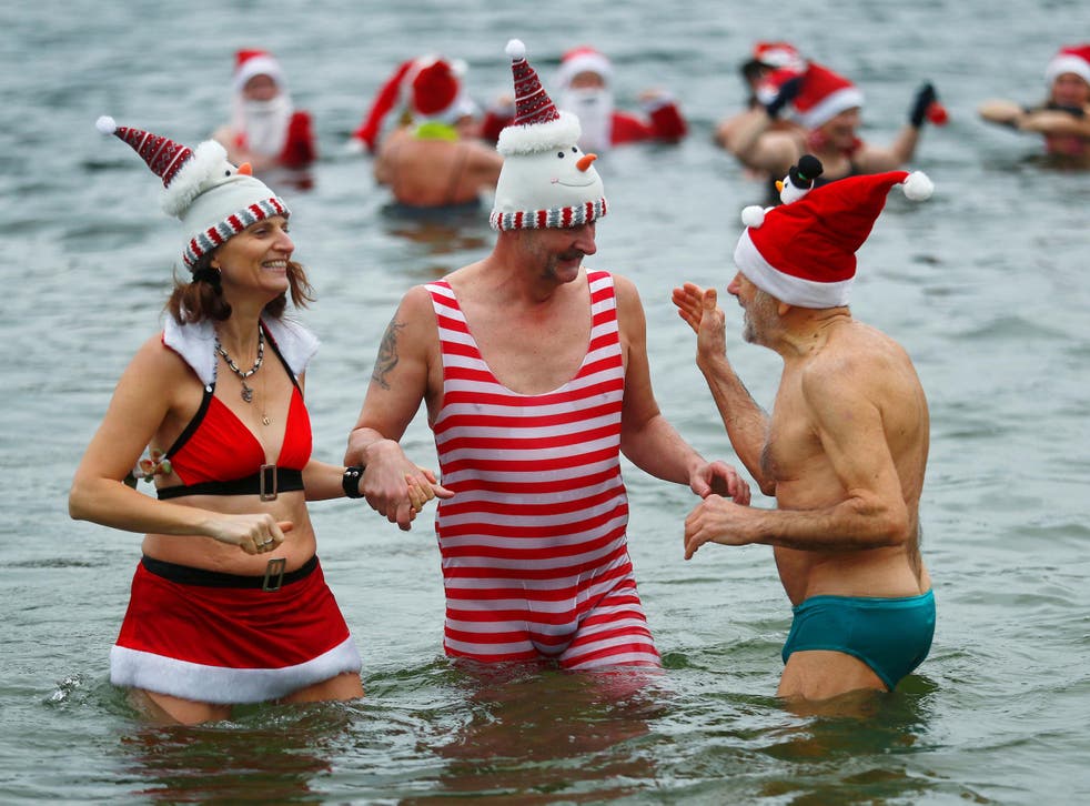 Members of ice swimming club ‘Berliner Seehunde’ – which means Berlin Seals – take a dip in the Orankesee lake in Berlin as part of their traditional Christmas ice swimming session