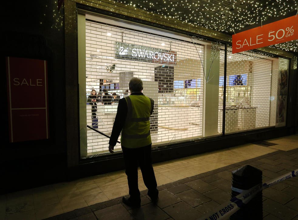 A security guard stands in front of a shattered window at the rear of House of Fraser on London's Oxford Street
