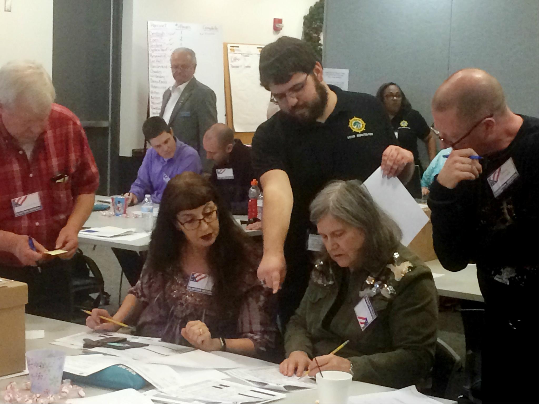Election officials in Newport News, Virginia examine ballots that a computer failed to scan during a recount for a House of Delegates race on 19 December 2017.