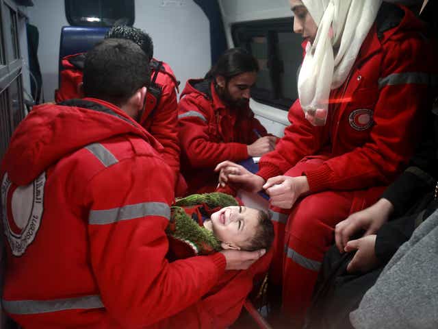 Syrian staff from the International Committee of the Red Cross evacuate a baby in Douma in the eastern Ghouta region on the outskirts of the capital Damascus