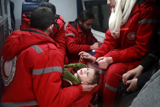 Syrian staff from the International Committee of the Red Cross evacuate a baby in Douma in the eastern Ghouta region on the outskirts of the capital Damascus