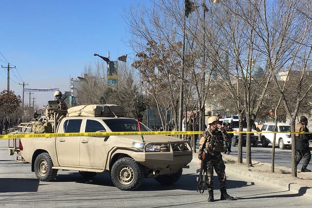 Afghan security forces stand guard near the site of previous blasts in Kabul on 28 December