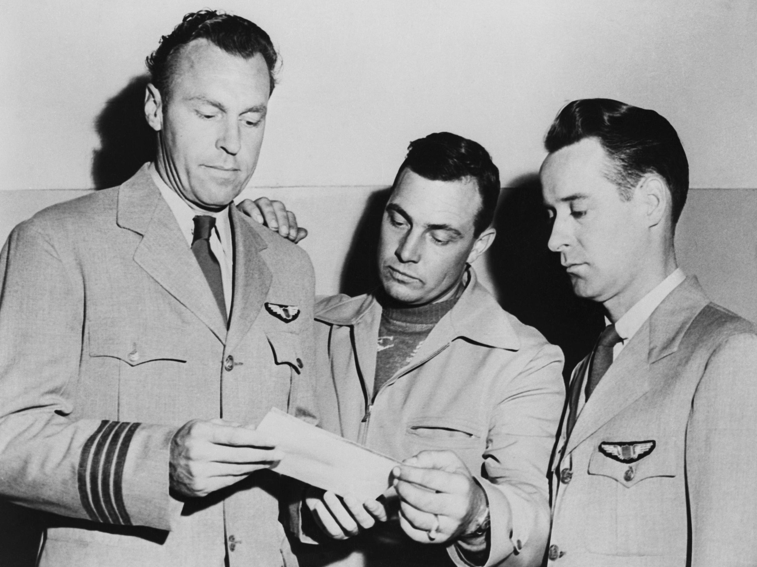 Pilots EJ Smith, Kenneth Arnold and Ralph E Stevens look at a photo of the UFO they saw