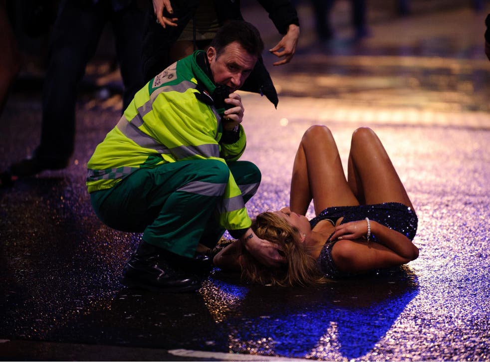 A St John’s Ambulance worker tries to help a drunk young woman in Cardiff, a city which runs Alcohol Intoxication Management Services
