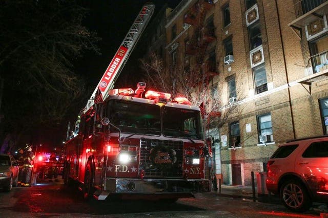 Fire Department of New York personnel work on the scene of an apartment fire in Bronx, New York