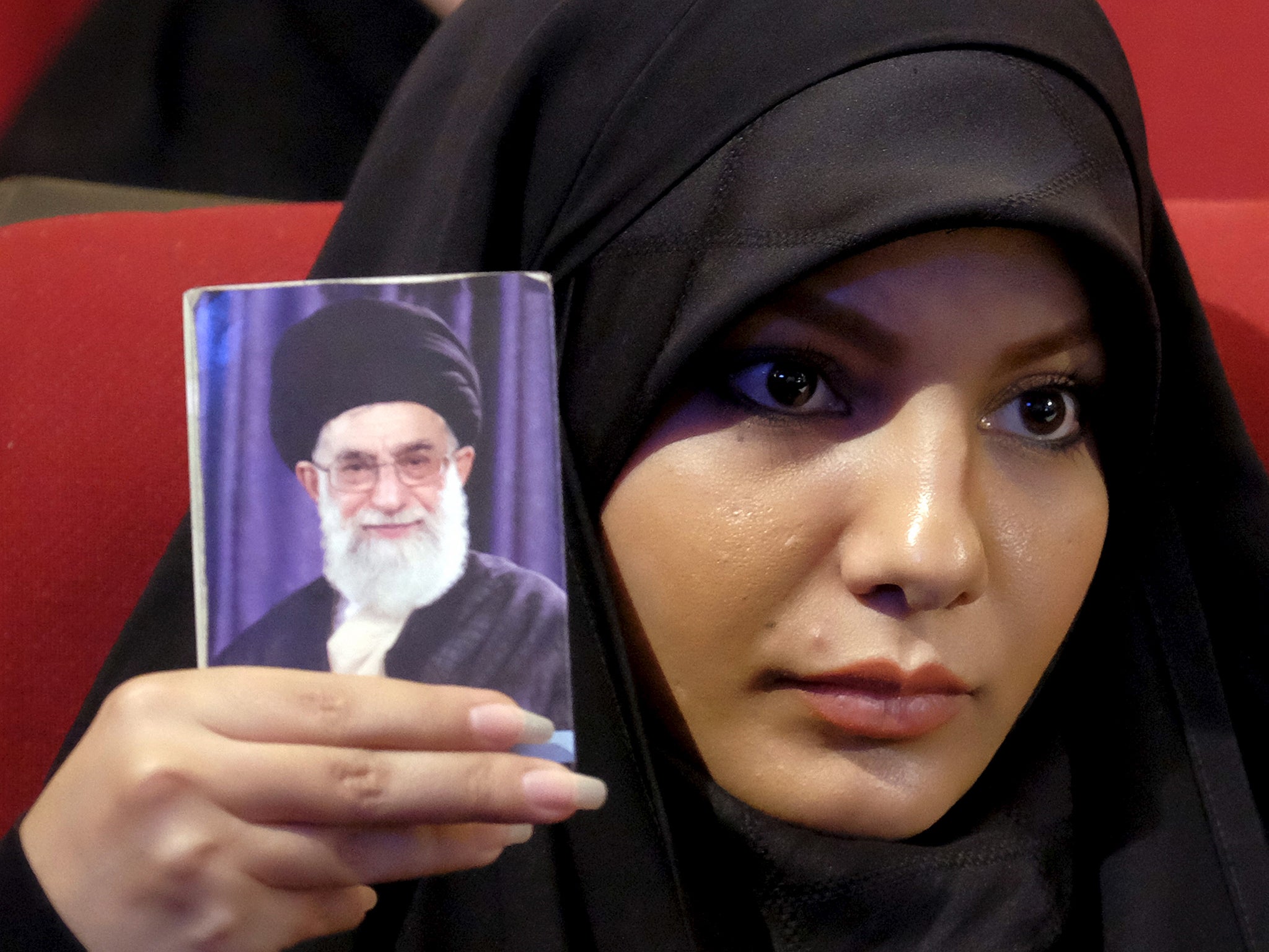 An Iranian woman holds a picture of the country's Supreme Leader Ayatollah Ali Khamenei