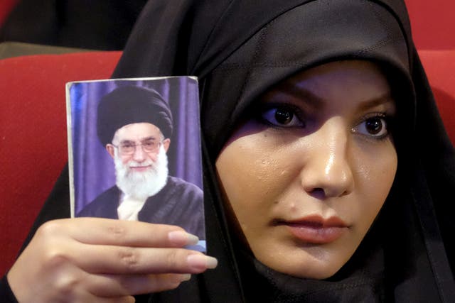 An Iranian woman holds a picture of the country's Supreme Leader Ayatollah Ali Khamenei