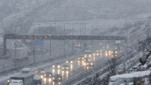Snow causes difficult driving conditions at junction 22 of the the M62 motorway at Saddleworth in the South Pennines