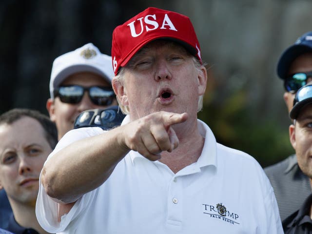 President Donald Trump speaks as he meets with members of the US Coast Guard, who he invited to play golf at Trump International in West Palm Beach, Florida