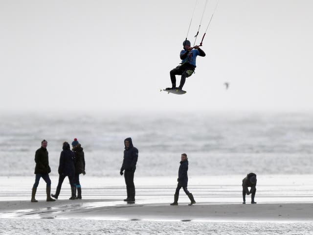 A kite surfer enjoys the strong winds on West Wittering beach in West Sussex