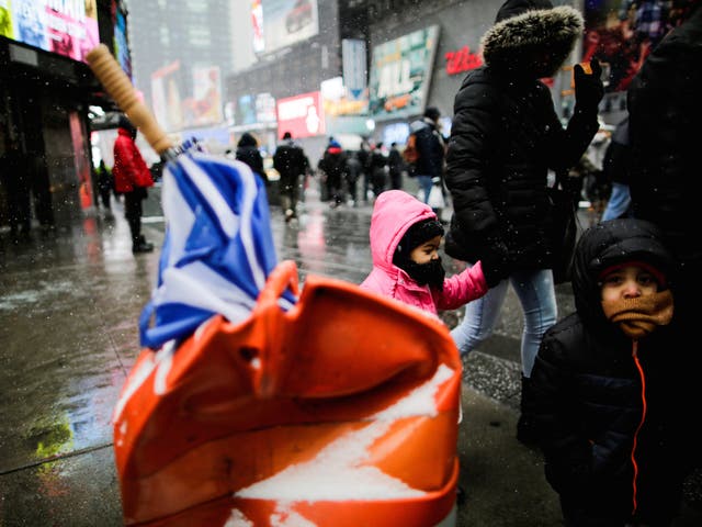 People walk around Times Square as a cold weather front hits the region in Manhattan, New York