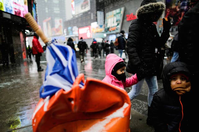 People walk around Times Square as a cold weather front hits the region in Manhattan, New York