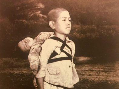 A boy carries his dead brother on his shoulders while he waits at a cemetery in Nagasaki in an image taken by US Marine Joe O'Donnell in 1945