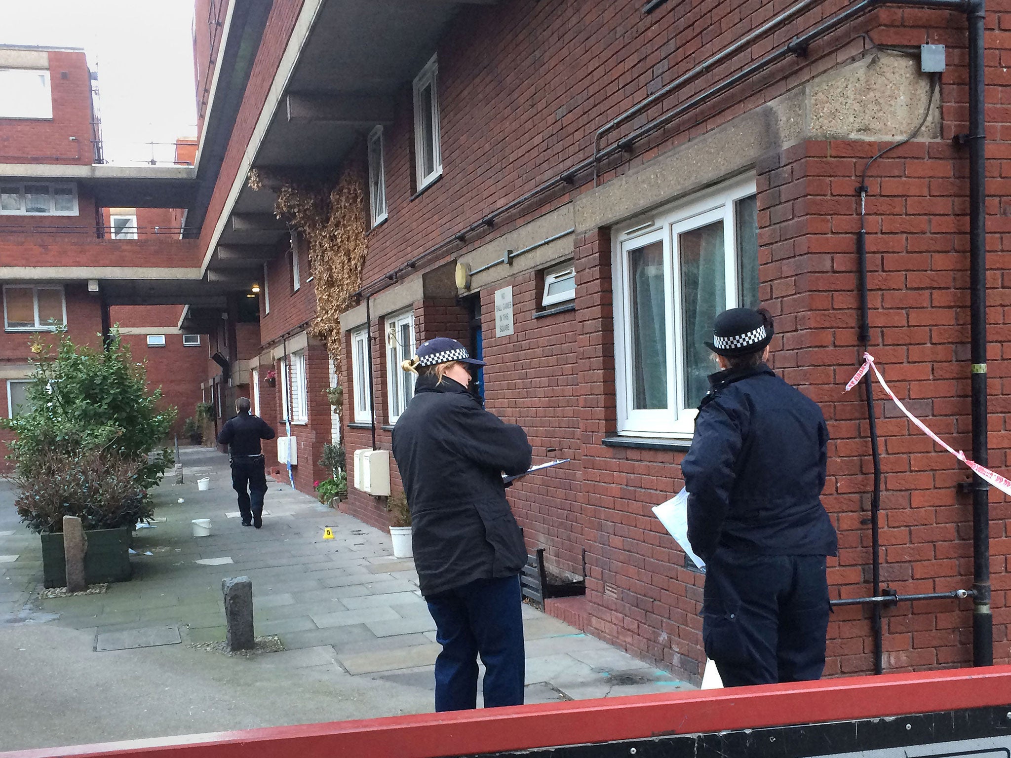 Police and forensic officers at the scene of a stabbing at Bartholomew Court, near Old Street in London