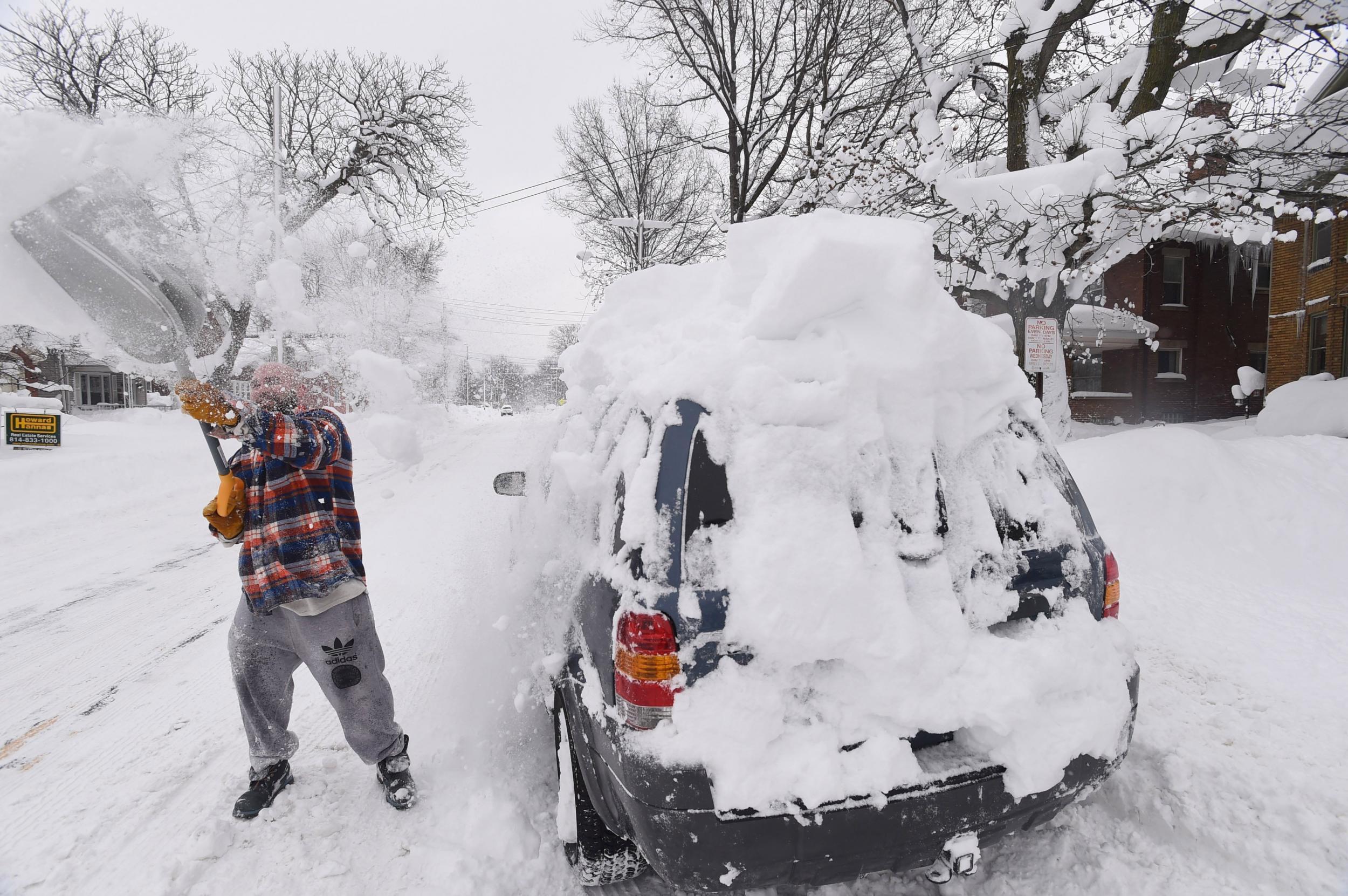 Kevin Deiner of Erie, Pennsylvania., digs out his Ford Escape from the snow