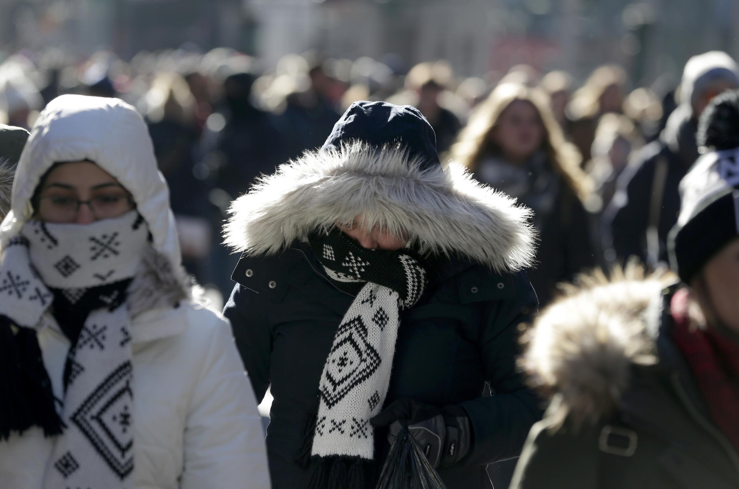 Pedestrians try to keep warm while walking in New York's Times Square