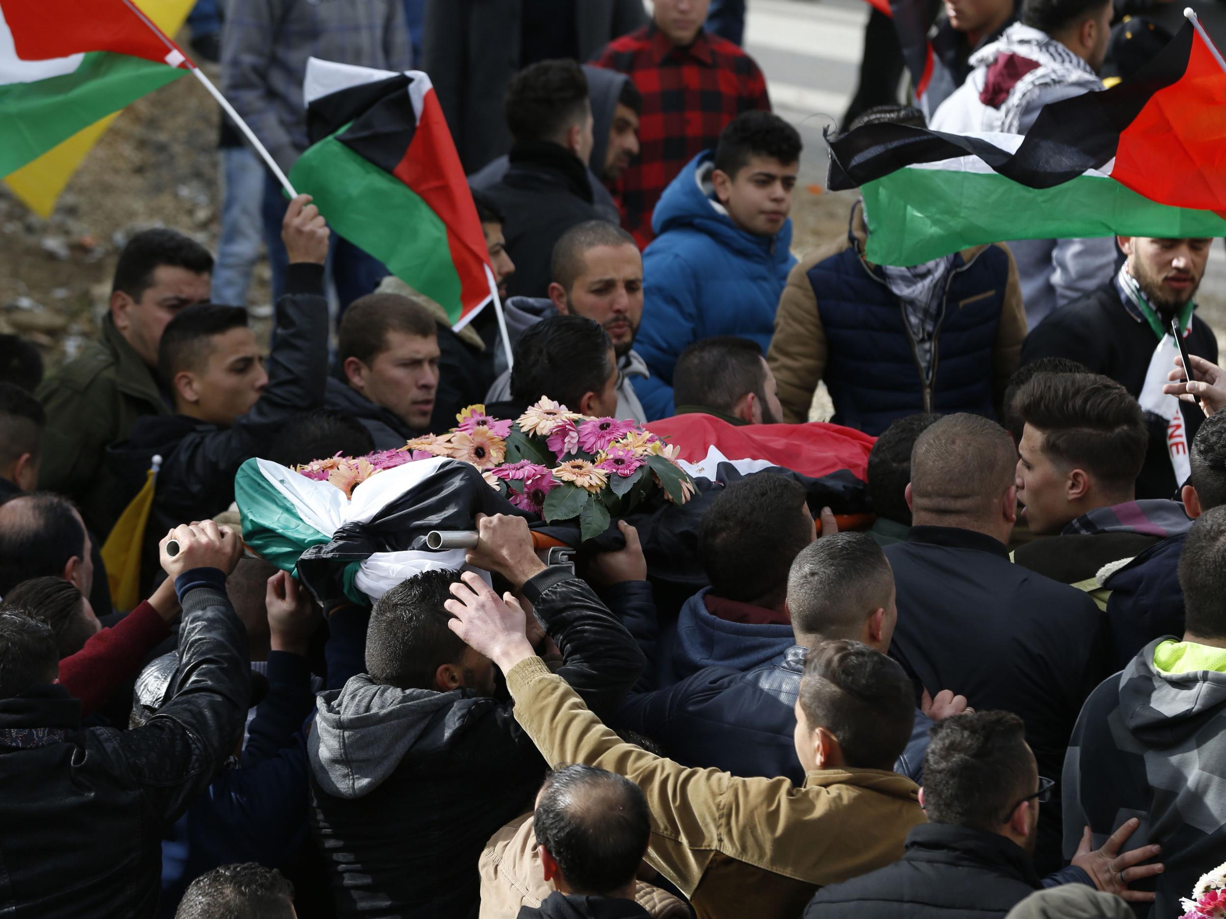 Palestinian mourners carry the body of Musab Firas al-Tamimi, 17, who was shot dead in clashes with the Israeli army a day earlier, during his funeral in the village of Deir Nizam north of Ramallah in the occupied West Bank, on 4 January 2018