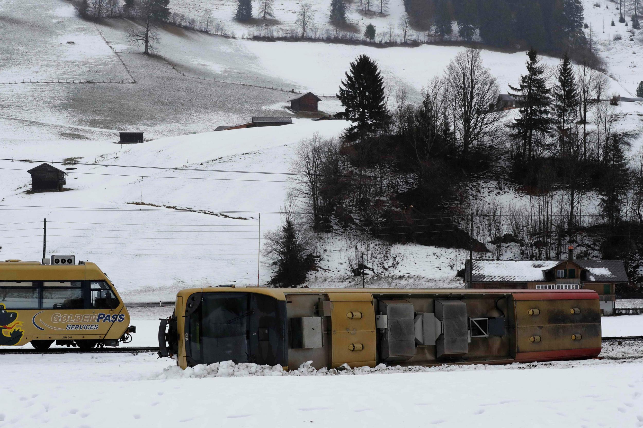 A carriage of the Montreux Oberland Bernois train is pictured lying on its side after if was pushed off the tracks by gusts of wind during Storm Eleanor near Lenk in Switzerland (Reuters)