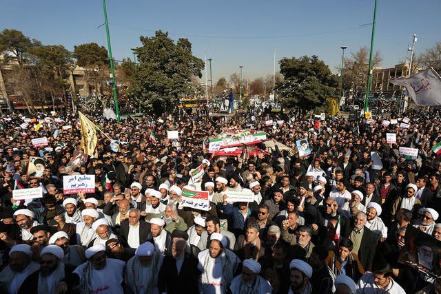 Pro-government demonstrators hold banners during a march in the central Iranian city of Isfahan